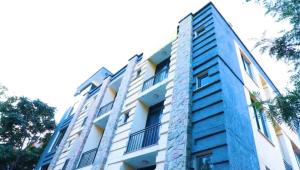 a tall blue building with trees in front of it at Kings Land Hotel in Lalībela +25 photos