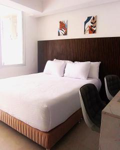 a bedroom with a large bed and a chair at Magica Cartagena Suite in Cartagena de Indias +56 photos