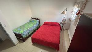una piccola camera con un letto e una coperta rossa di Don Francisco a Junín