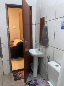 a small bathroom with a sink and a toilet at Casa completa com dois quartos e estacionamento grátis in Serra