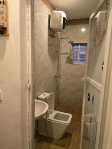 a small bathroom with a toilet and a sink at Rehoboth in Mama