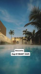 卡达斯诺瓦斯A Casa Paradisíaca ll Luxo Piscina Super Quente até 50 graus Aquecimento Elétrico e Solar Casa com Sauna a Vapor e Ar Condicionado em Todos Ambientes e Lavanderia com Roupa de Cama e Banho e Ofurô Super Quente Temos Lareira , Com Valores adicionais的棕榈树游泳池前的标志