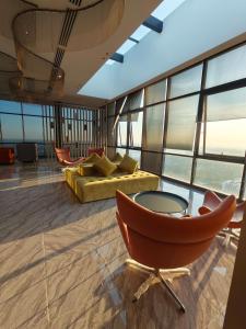 a living room with a yellow couch and chairs at Mesahill Premier Suite-Wi-Fi-NETFLIX in Nilai