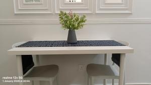 a table with two chairs and a vase with flowers on it at Mesahill Premier Suite-Wi-Fi-NETFLIX in Nilai +46 photos