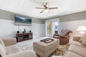 a living room with two chairs and a flat screen tv at Allendale Docks in Destin