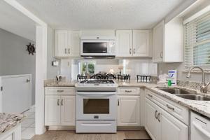 a kitchen with white cabinets and a stove top oven at Allendale Docks in Destin