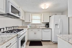 a kitchen with white cabinets and a white refrigerator at Allendale Docks in Destin +17 photos