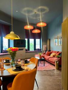 un soggiorno con un tavolo e un divano di The Bank - Rooms & Apartments by Coorie Doon Stays a Troon