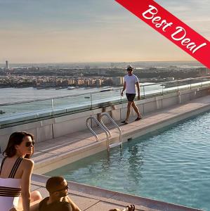 a man standing on the edge of a rooftop swimming pool at CARIBE TROPICAL - SUITES and STUDIOS - playa LOS CORALES in Punta Cana