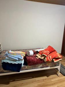 een bed met een stapel kleren erop bij Leomil-House in Leomil