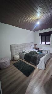 een slaapkamer met een groot bed en een houten vloer bij Leomil-House in Leomil