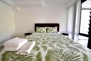 a bedroom with a large bed with towels on it at Lagoon Apartments in Nuku‘alofa