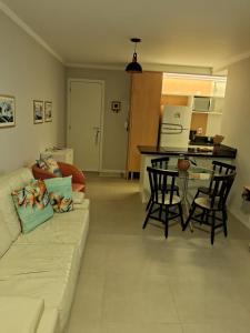 a living room with a couch and a table at Apartamento novo entre a praia dos Ingleses e Santinho in Florianópolis