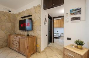 a living room with a tv on a stone wall at Dimora Karalis in Cagliari