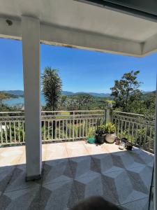 a balcony with potted plants and a view of the water at Varanda do Céu Paraty in Paraty