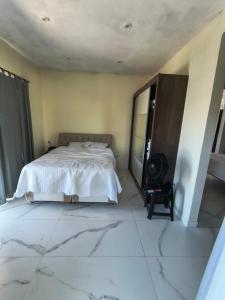 a bedroom with a white bed and a mirror at Varanda do Céu Paraty in Paraty