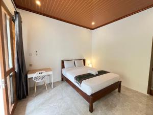 a bedroom with a bed and a desk in a room at Kuta Garden in Kuta Lombok