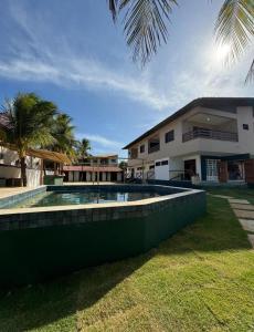 a swimming pool in front of a house at BRKITE Pousada in Cumbuco