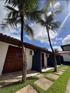 a house with two palm trees in front of it at BRKITE Pousada in Cumbuco