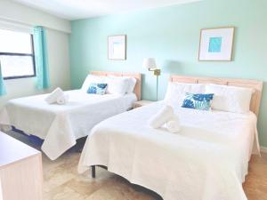 En eller flere senge i et værelse på Beachfront Condo, Direct Access to Sugar Sand Beach, Heated Pool and Balcony Views