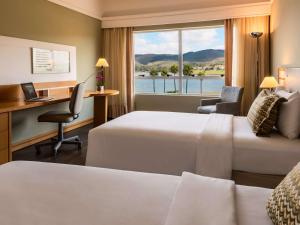 a hotel room with two beds and a desk and a window at Transamerica Lagoa dos Ingleses in Nova Lima