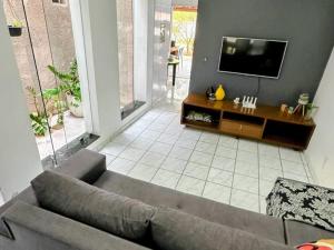a living room with a couch and a flat screen tv at Casa do Sertão in Piranhas