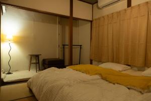 a bedroom with a bed and a lamp in it at Guest House KITOEDA in Nikko