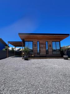 a small house with a roof on a gravel yard at Cabana Maciambu casa de praia Palhoça SC in Palhoça