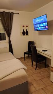 a hotel room with a bed and a desk and a tv at Zimmervermietung Heggemann in Lingen