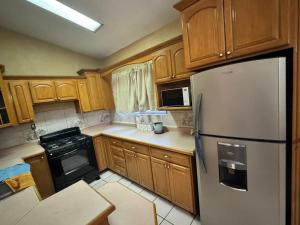 a kitchen with wooden cabinets and a stainless steel refrigerator at Casa visas656 in Manuel F. Martínez
