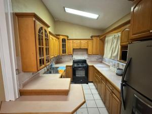 a kitchen with wooden cabinets and a black stove at Casa visas656 in Manuel F. Martínez