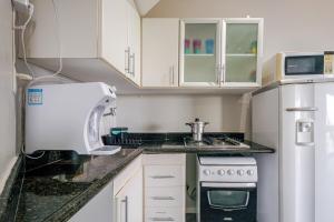 een keuken met witte kasten en een aanrechtblad bij Lindo Vista Mar, Praia do Buracão - Rio Vermelho in Salvador