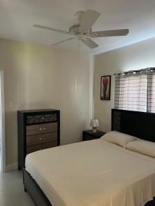 a bedroom with a bed and a ceiling fan at Gate home by ocean point in Lucea
