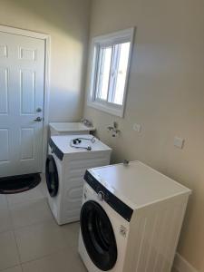 a laundry room with a washing machine and a window at Gate home by ocean point in Lucea