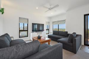 a living room with two couches and a tv at Wheeler's Paradise in Paradise Beach