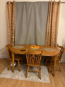 een houten tafel met stoelen en een fruitschaal erop bij Riverchapel Guesthouse in Courtown