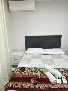 a bedroom with a bed with a black and white bedspread at Quarto Suíte Na grande Florianopolis in São José