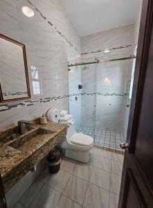 a bathroom with a shower and a toilet and a sink at Mi Cassa Real Degollado Hotel #4 in Degollado