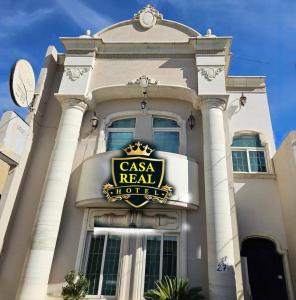 a tall white building with a sign on it at Mi Cassa Real Degollado Hotel #4 in Degollado