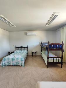 ein Schlafzimmer mit zwei Betten in einem Zimmer in der Unterkunft Suíte na Canastra com Ar Condicionado in São Roque de Minas