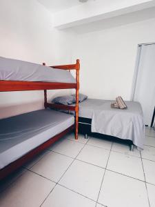 2 letti a castello in una camera con pavimento piastrellato di Surf & Arte Hostel a Cabo Frio Altre 9 foto