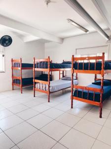 una stanza con tre letti a castello in una stanza di Surf & Arte Hostel a Cabo Frio