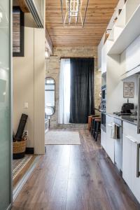 a kitchen with a wooden ceiling and a hallway at Bradshaw Lofts The Brixton King Suite in Stratford
