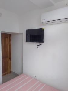 una camera da letto con un letto e una TV a parete di Acogedor apartamento a Apartadó