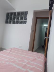 una camera con letto, finestra e specchio di Acogedor apartamento a Apartadó