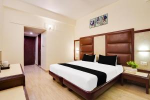 a bedroom with a large bed in a hotel room at Townhouse Oak Silver City Chowk Formerly HW Residency in Dehradun