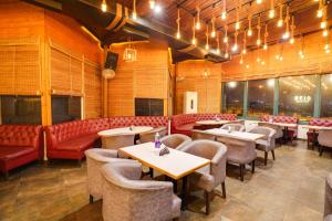 a restaurant with tables and chairs and couches at Townhouse Oak Silver City Chowk Formerly HW Residency in Dehradun +52 photos