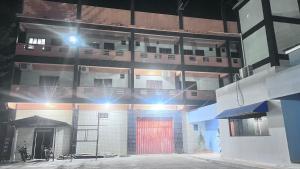 a building with a red door at night at Braz Hotel in Tomé-Açu