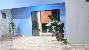 a blue room with a door and a vase with flowers at Braz Hotel in Tomé-Açu