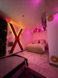 een kamer met roze verlichting, een bed en een bank bij Asdreamslove in Alès